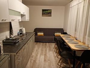 a kitchen and living room with a table and a couch at Idylla in Połom Mały