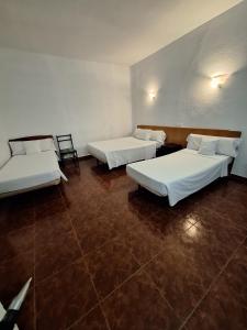 a room with three beds in a room at Hostal Alonso No Limit Madrid in Madrid