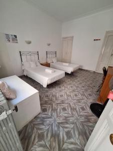 a room with two beds and ailed floor at Hostal Alonso No Limit Madrid in Madrid +22 photos