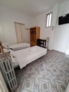 a bedroom with two beds and a flat screen tv at Hostal Alonso No Limit Madrid in Madrid