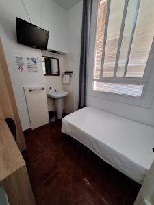 a small room with a bed and a window at Hostal Alonso No Limit Madrid in Madrid