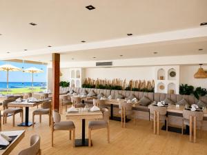 a restaurant with tables and couches and chairs at XU Sidi Abdel Rahman Resort & Spa in El Alamein