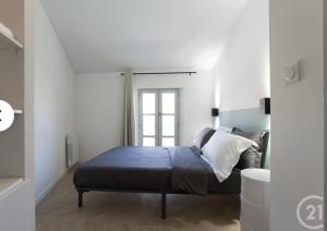 a bedroom with a bed and a window at Cocon Voltaire - Arles centre historique in Arles