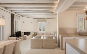 a living room with a couch and a table at Andros Royal Villa in Koumárion