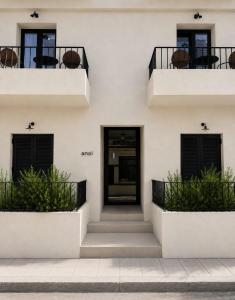 a white house with a black door and balcony at Anoi Kefalonia in Argostoli