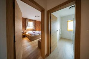 a room with a bedroom with a bed and a glass door at Hiša Tam Čez in Slovenj Gradec