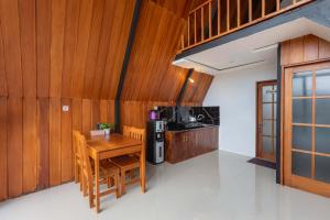 a kitchen with wooden walls and a wooden table and chairs at Villa Platinum 2 in Banjarnegara