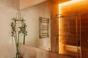 a bathroom with a shower with a mirror and a plant at Fomich Estates in Bukovel +47 photos