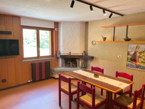 a dining room with a table and chairs and a fireplace at Monterosa Paradise in Gressoney-la-Trinité