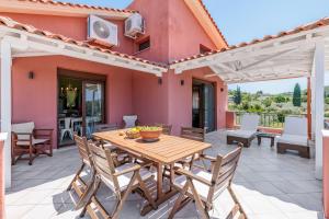 a patio with a wooden table and chairs at Luxury Villa with Private Pool in Skopelos, Spacious & Private, Villa Amaryllis By Kardous in Alikias