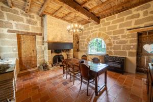 a dining room with a table and a fireplace at Castel La Fabrik'Créative in Saint-Barthélémy-dʼAgenais