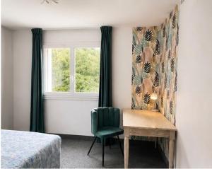 a bedroom with a green chair and a table and a window at Le Napoléon in Corps