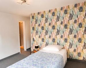 a bedroom with a bed with a floral wallpaper at Le Napoléon in Corps