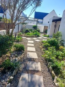 a garden with a stepping stone path in front of a house at Harts Water in Jacobs Bay