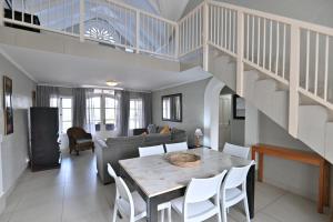 a living room with a table and a staircase at Caribbean Estates by MyResorts in Port Edward