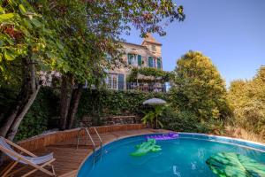 a swimming pool in front of a house at Castel La Fabrik'Créative in Saint-Barthélémy-dʼAgenais