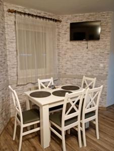 a dining room with a white table and chairs at Idylla in Połom Mały