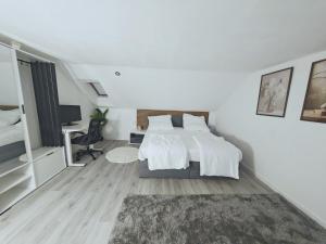 a white bedroom with a bed and a desk at Unterkunft in Eggenfelden in Eggenfelden