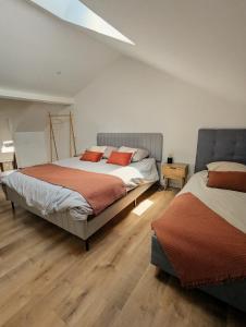 two beds in a bedroom with wooden floors at Maison hyper centre Jacuzzi in Amboise