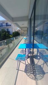 a patio with blue tables and chairs on a building at Vila Arthur in Eforie Nord