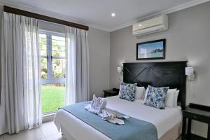 a bedroom with a bed and a large window at Caribbean Estates by MyResorts in Port Edward +54 photos