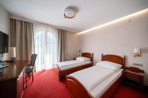 a hotel room with two beds and a desk at Dworek Skawiński in Skawina