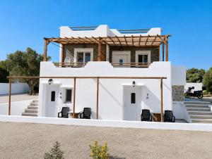 a white house with chairs in front of it at Countryside Retreat 3 in Agios Arsenios