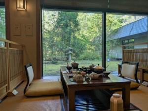 a dining room with a table and a large window at Shirafune Grand Hotel in Matsumoto