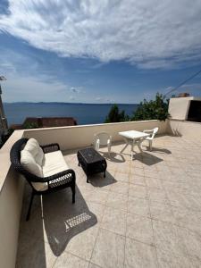 a patio with chairs and a table on a roof at Studio Apartment Rose in Selca