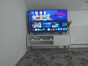 a flat screen tv sitting on top of a white cabinet at Unterkunft in Eggenfelden in Eggenfelden