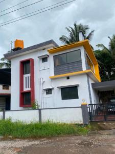 a white house with a red and white at Siya's home in Udupi