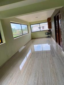 an empty room with two windows and a wooden floor at Siya's home in Udupi +1 photo