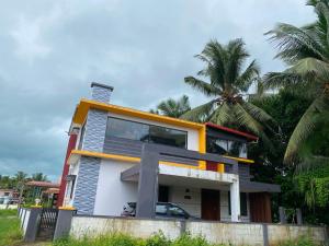 a house on the beach with a palm tree at Siya's home in Udupi