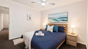 a bedroom with a bed with a blue comforter at Saltwater Stay in Bunbury