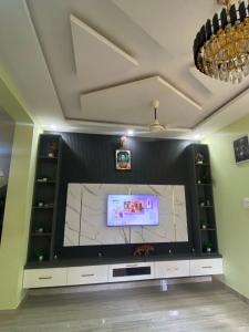 a large entertainment center with a large screen television at Siya's home in Udupi