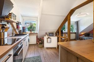 a kitchen with white counters and wooden floors at Ferienwohnung an der Bieke in Olsberg