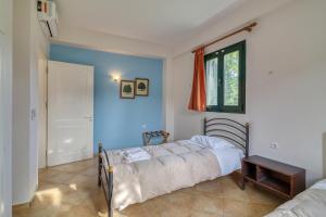 a bedroom with a bed and a blue wall at Analipsi Villas Beach Front in Kástro Tornéze