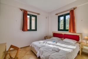 a bedroom with a bed and two windows at Analipsi Villas Beach Front in Kástro Tornéze