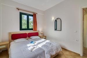 a bedroom with a large bed with a red headboard at Analipsi Villas Beach Front in Kástro Tornéze