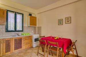 a kitchen with a table with a red table cloth on it at Analipsi Villas Beach Front in Kástro Tornéze