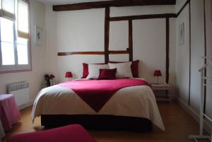 a bedroom with a large bed with a red blanket at LE RELAIS DU BON'EURE in Évreux