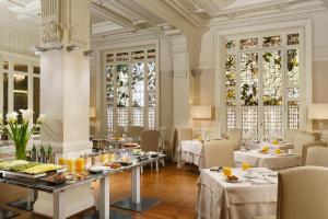 a dining room with tables and chairs and windows at Brunelleschi Hotel in Florence
