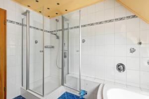 a shower in a bathroom with white tiles at Geräumiges Haus mit Garten Terasse in Nuremberg +26 photos
