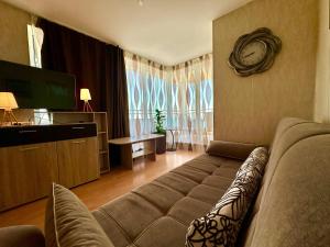 a living room with a couch and a television at Cozy Corner Studio in Crown Fort in Sveti Vlas