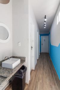 a bathroom with a sink and a hallway at Hostel Leblon in Rio de Janeiro +101 photos