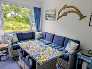 a living room with a blue couch and a table at 21 The Glade in Bude