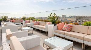 a patio with couches and tables on a roof at Hotel Porto Downtown in Porto
