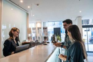 a group of people standing around a counter in a store at Hotel Porto Downtown in Porto