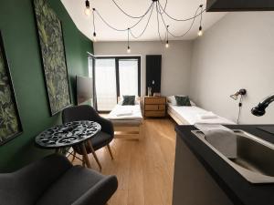 a living room with a couch and a table and a sink at Nad Jeziorem dla przyjaciół Apartament in Serock