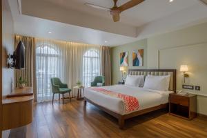 a bedroom with a bed and two chairs and a television at Ginger Rishikesh, Dehradun Road in Rishīkesh +22 photos